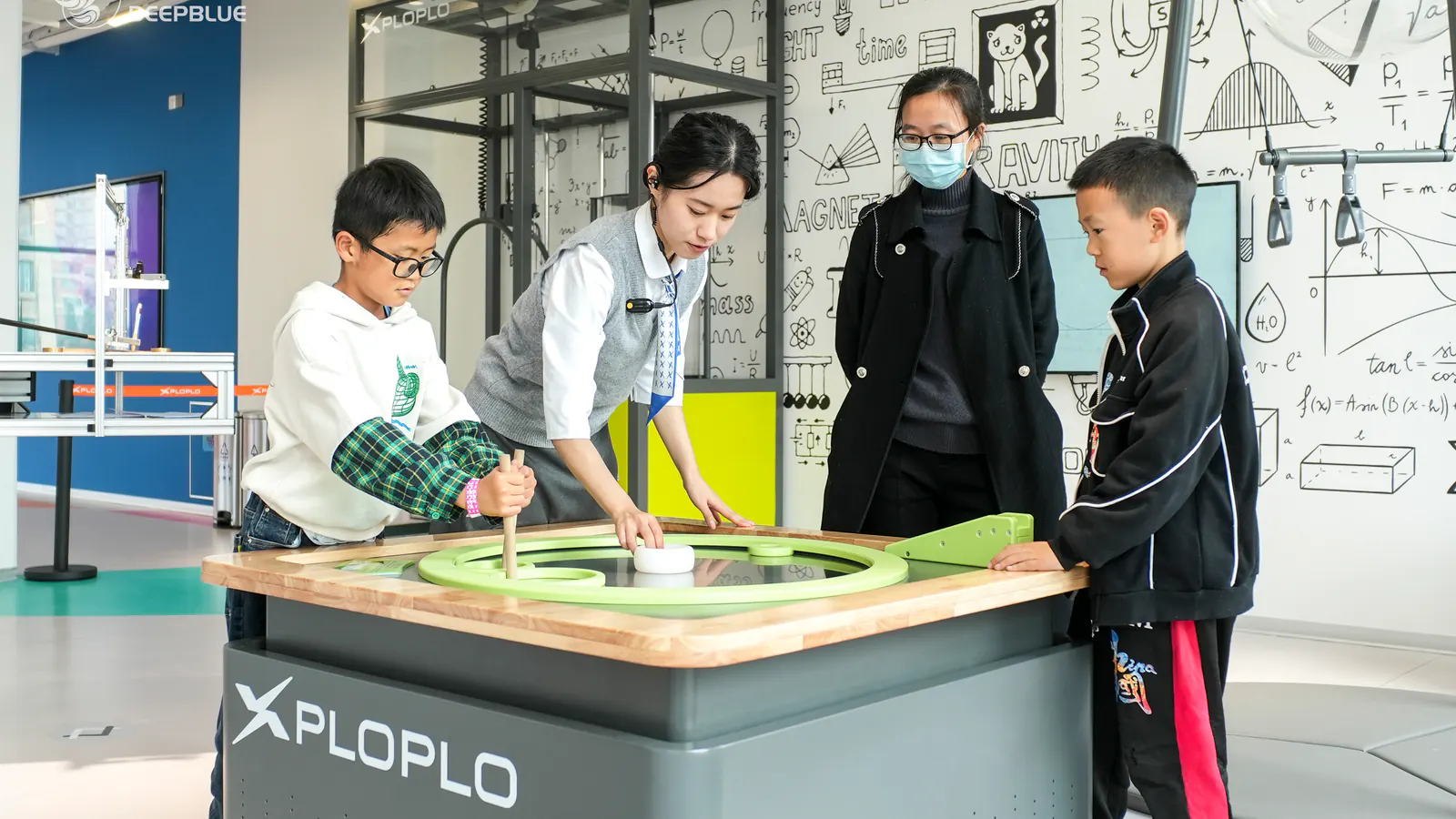 XPLOPLO educator guiding children around an interactive exhibit during venue operation