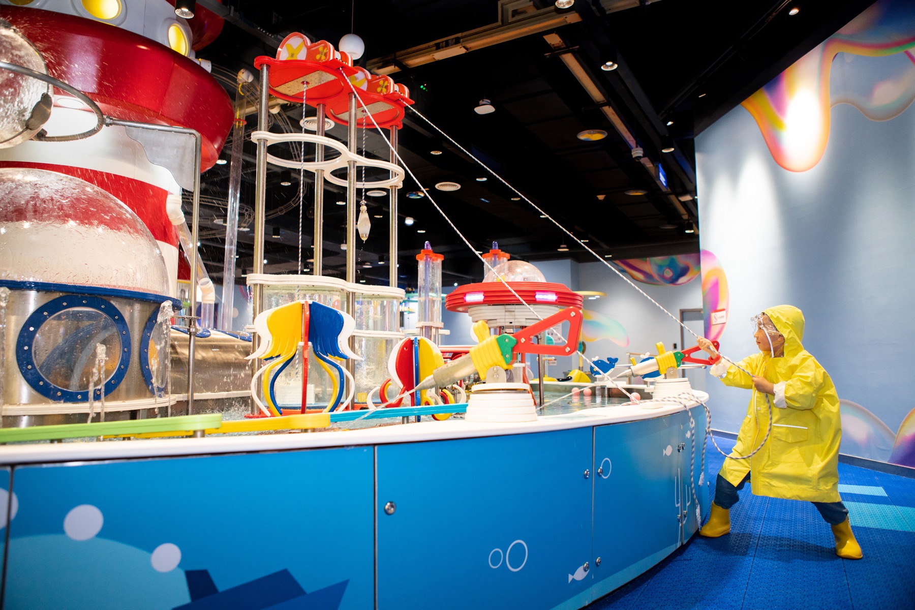 Child interacting with a water science exhibit in a completed DEEPBLUE venue