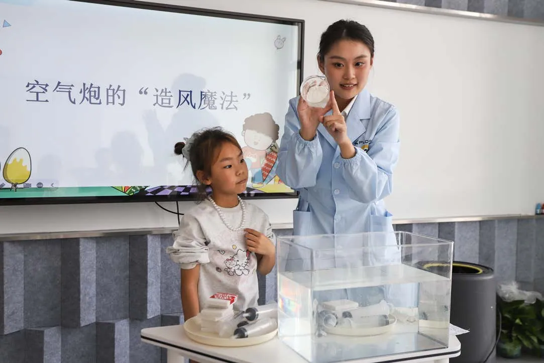 Educator demonstrating an air cannon activity for children at XPLOPLO