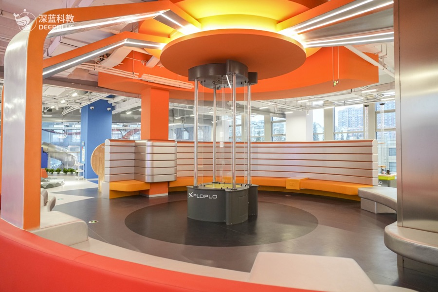 XPLOPLO second-floor themed science area with yellow and blue equipment