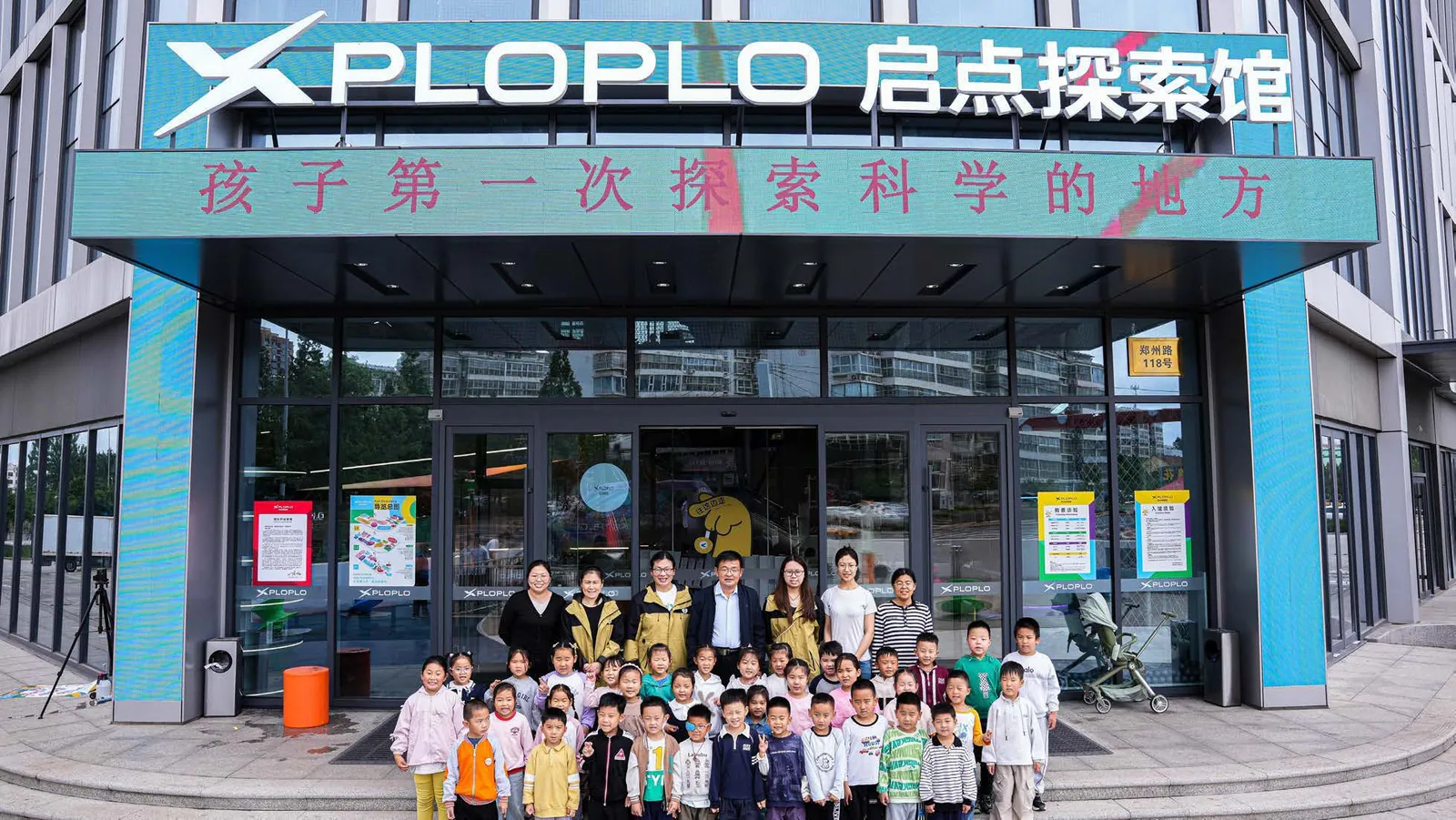 Children and families taking a study-tour group photo at the XPLOPLO entrance