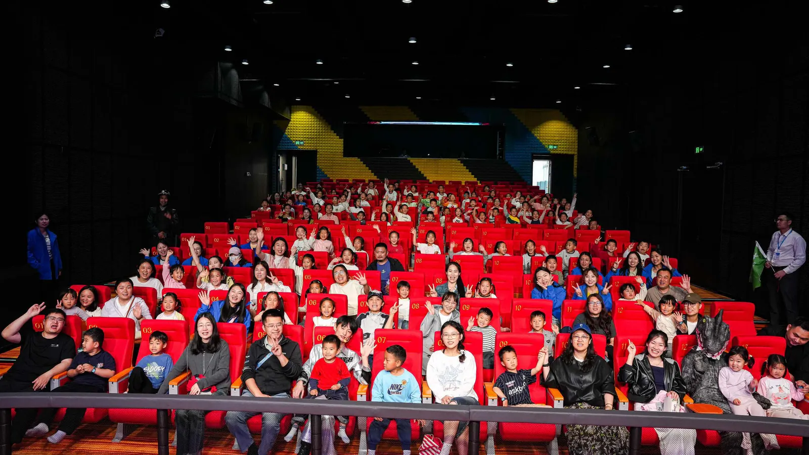 Children and parents taking a group photo in the XPLOPLO WOW Auditorium